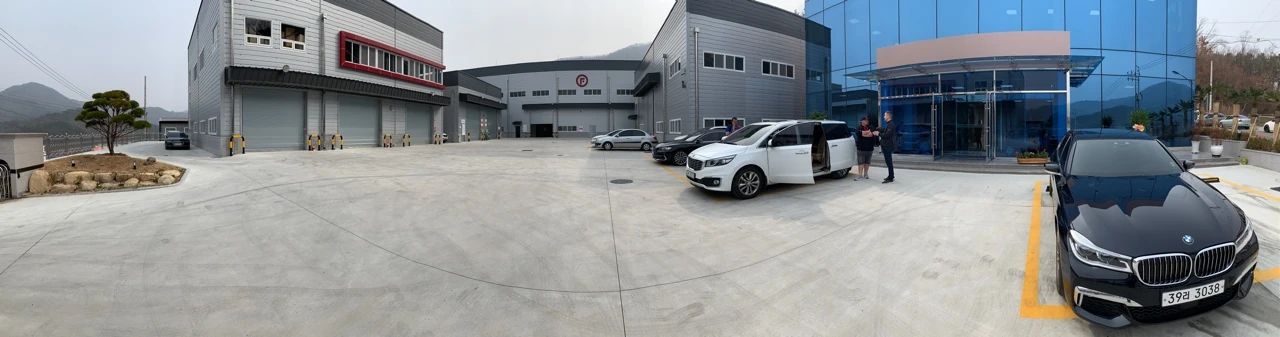 Our Legacy of Excellence in Auto Care Panoramic view of Fireball Korea’s factory exterior, visitors and vehicles in 2019