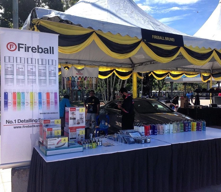 Our Legacy of Excellence in Auto Care Fireball Brunei outdoor booth with car-care products, vehicle and branded banners